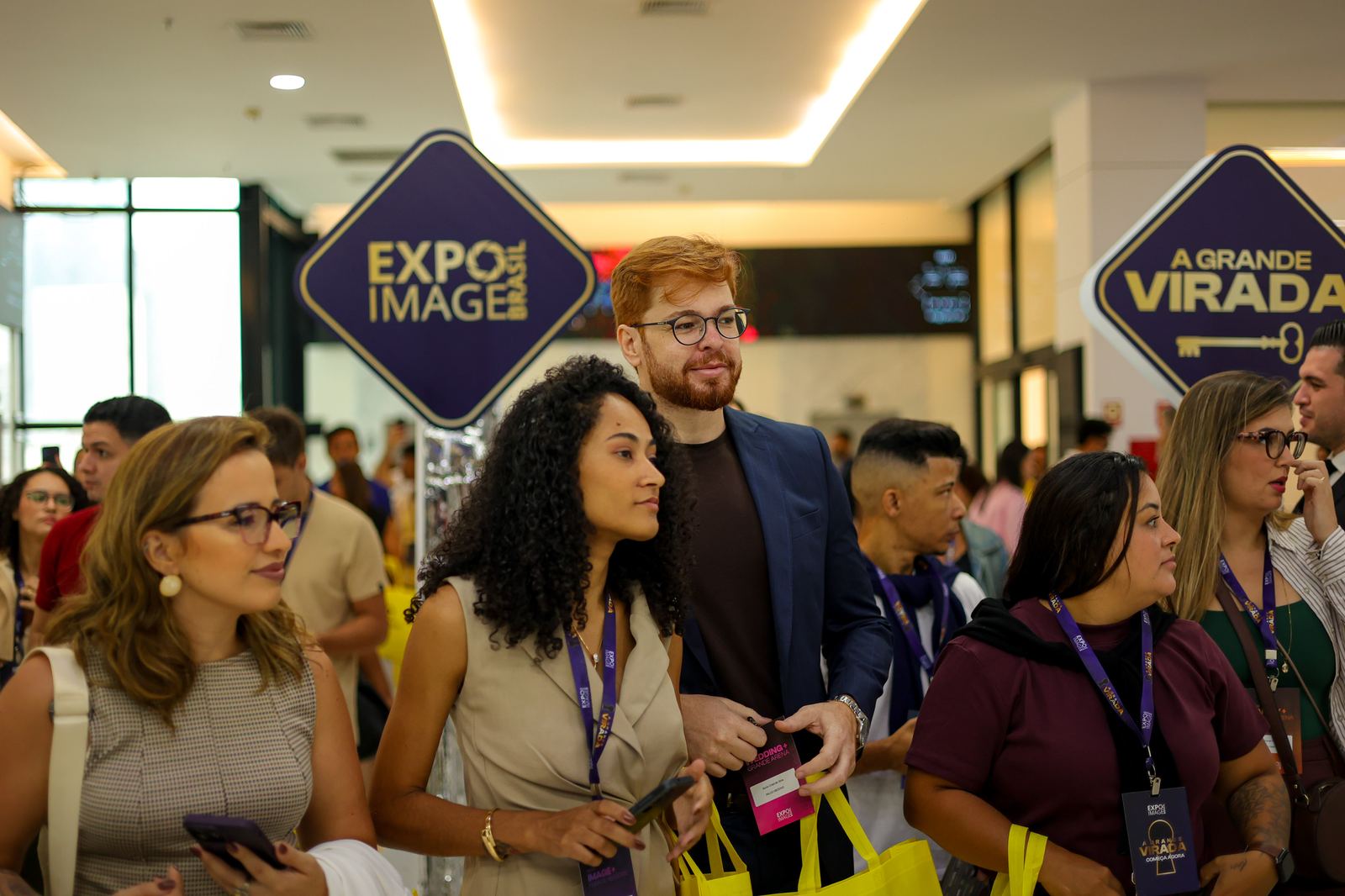 Hall da ExpoImage Brasil 2026: público com credenciais passando pelos totens do evento